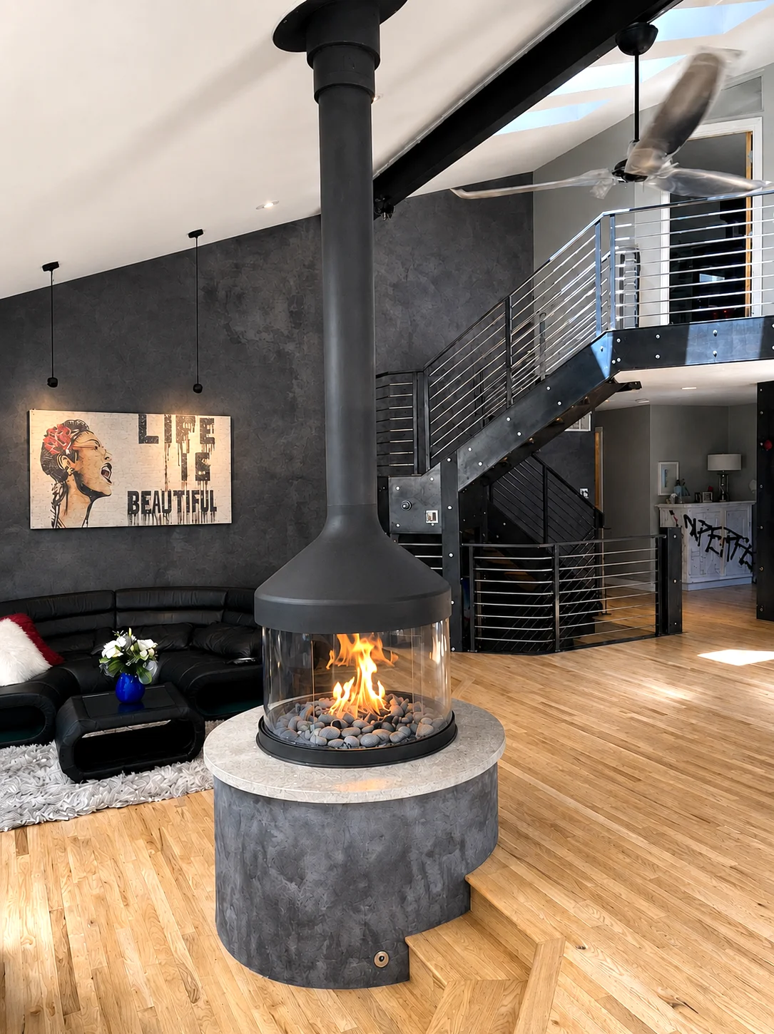 Central fireplace, steel staircase and Life Is Beautiful artwork in the living area