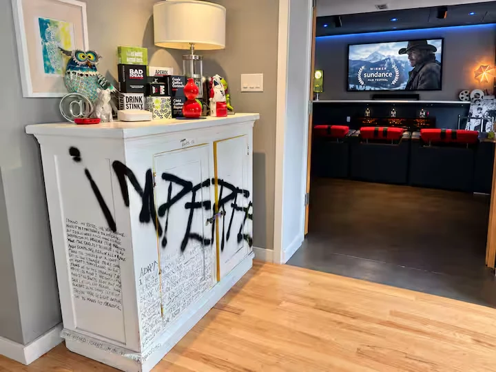 Street-art-inspired white cabinet with collectibles beside the cinema doorway